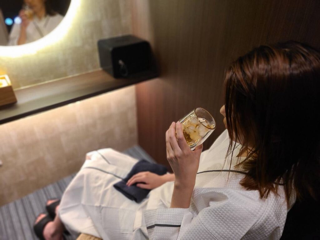 ご入浴後、半個室でドリンクを楽しむ女性